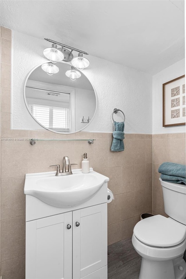 1370 NE 40th Dr, Oakland Park, FL 33334 - bathroom featuring tile walls, vanity, and wainscoting