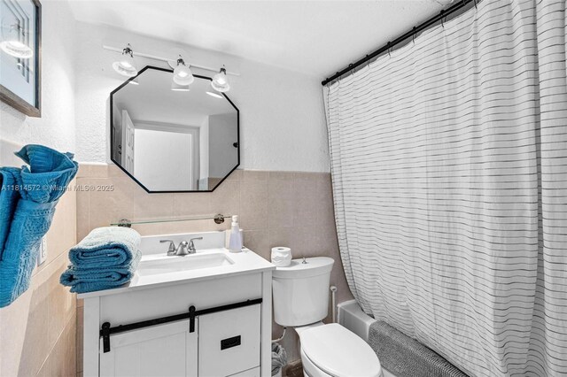 1370 NE 40th Dr, Oakland Park, FL 33334 - bathroom featuring tile walls, vanity, shower / tub combo, and wainscoting