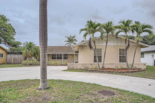 9802 N Military Trl, Palm Beach Gardens, FL 33410 - view of front of home with curved driveway, stucco siding, and brick siding