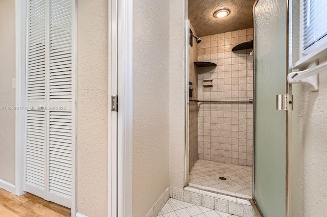 9802 N Military Trl, Palm Beach Gardens, FL 33410 - full bathroom featuring a shower stall, a textured wall, and baseboards