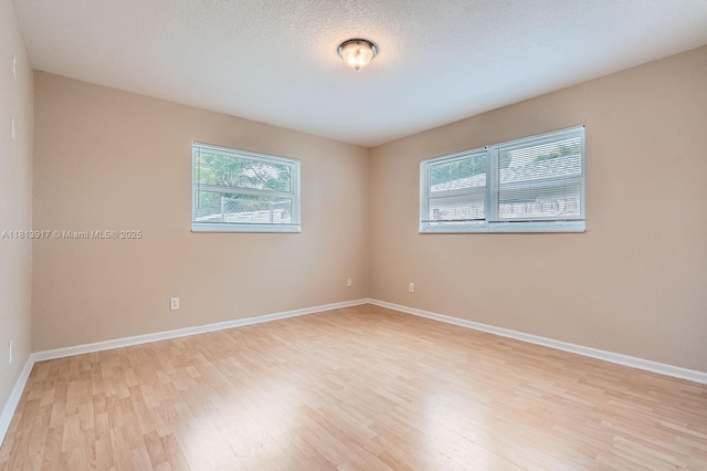 9802 N Military Trl, Palm Beach Gardens, FL 33410 - spare room with healthy amount of natural light, light wood-style flooring, and baseboards