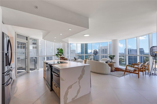 6301 Collins Ave Unit 1405, Miami Beach, FL 33141 - kitchen with stainless steel fridge, a view of city, a kitchen island, range with electric stovetop, and open floor plan