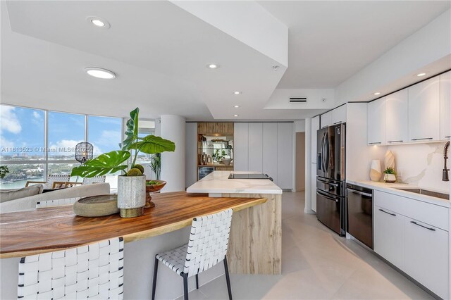 6301 Collins Ave Unit 1405, Miami Beach, FL 33141 - kitchen with fridge with ice dispenser, stainless steel dishwasher, modern cabinets, white cabinets, and recessed lighting