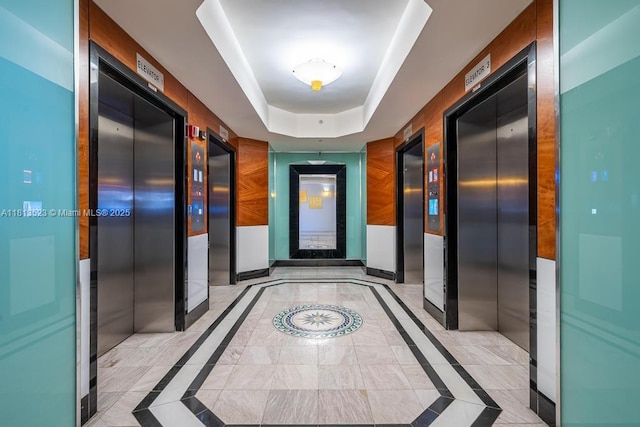 6301 Collins Ave Unit 1405, Miami Beach, FL 33141 - hallway featuring a raised ceiling, inlaid floor details, and elevator