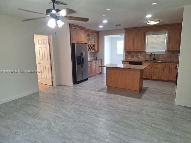 3961 Park Ln, Palm Springs, FL 33406 - kitchen with stainless steel fridge with ice dispenser, a center island, backsplash, a ceiling fan, and recessed lighting