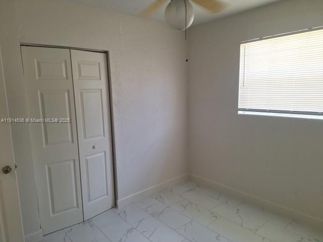 3961 Park Ln, Palm Springs, FL 33406 - unfurnished bedroom with light marble finish flooring, a closet, and ceiling fan