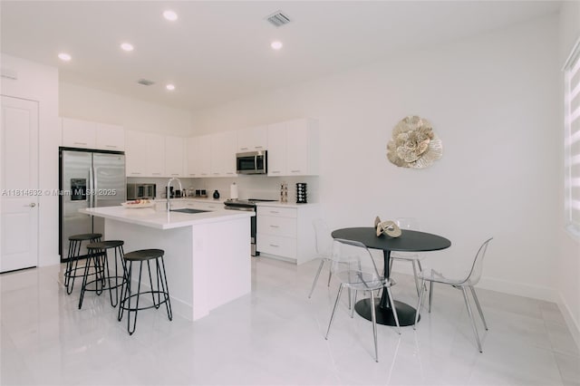 17451 SW 41st St, Miramar, FL 33029 - kitchen with stainless steel appliances, a kitchen breakfast bar, a sink, white cabinetry, and recessed lighting