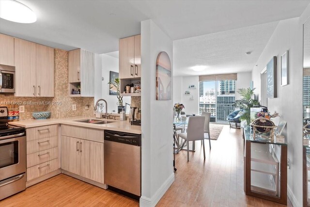1250 S Miami Ave Unit 2208, Miami, FL 33130 - kitchen with appliances with stainless steel finishes, light brown cabinets, a sink, light countertops, and light wood-style floors