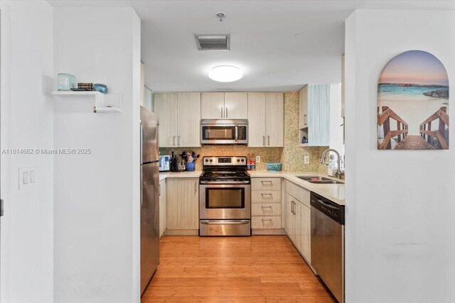 1250 S Miami Ave Unit 2208, Miami, FL 33130 - kitchen with stainless steel appliances, a sink, light wood finished floors, light countertops, and tasteful backsplash