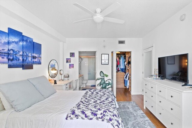 1250 S Miami Ave Unit 2208, Miami, FL 33130 - bedroom with a spacious closet, wood finished floors, a closet, connected bathroom, and a ceiling fan