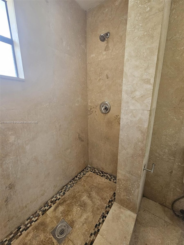 4131 NW 79th Ave Unit 4131, Sunrise, FL 33351 - bathroom featuring a tile shower and inlaid floor details