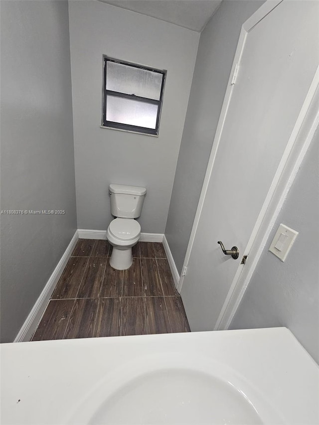 4131 NW 79th Ave Unit 4131, Sunrise, FL 33351 - bathroom with toilet, baseboards, and wood finished floors