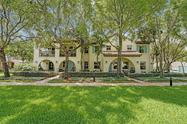 4284 Cascada Cir, Cooper City, FL 33024 - mediterranean / spanish-style home with a balcony, stucco siding, a front lawn, and a tiled roof