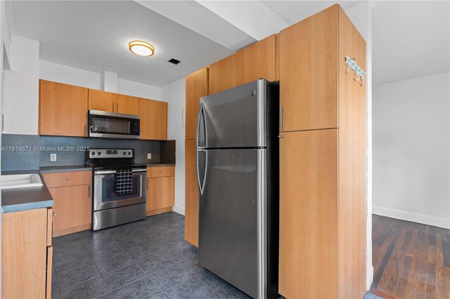 1105 NE 119th St, Biscayne Park, FL 33161 - kitchen featuring appliances with stainless steel finishes, dark tile patterned flooring, and backsplash
