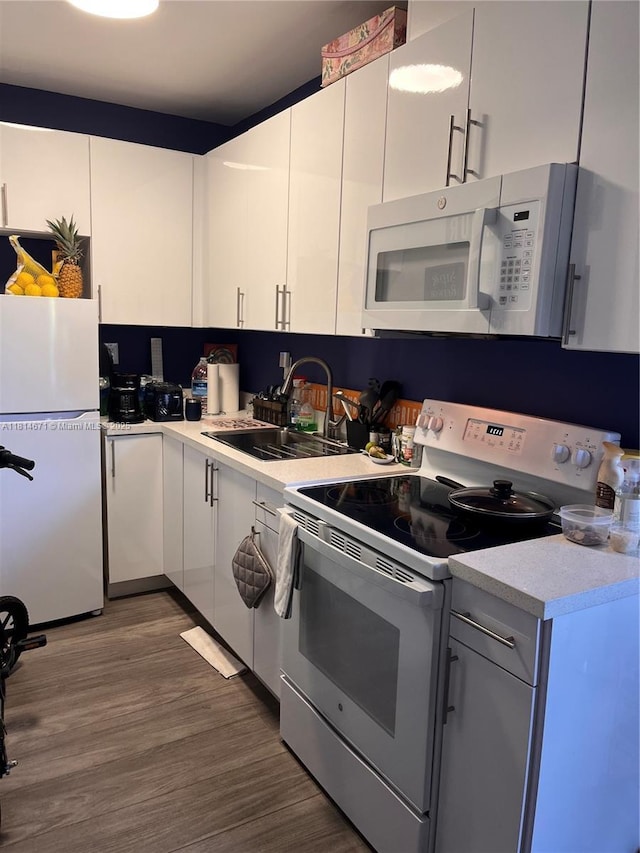 1105 NE 119th St, Biscayne Park, FL 33161 - kitchen with white appliances, light countertops, wood finished floors, and white cabinets