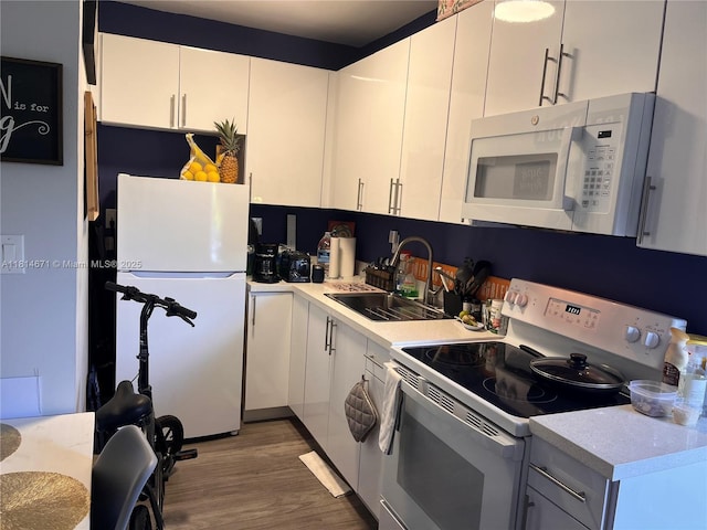 1105 NE 119th St, Biscayne Park, FL 33161 - kitchen featuring white appliances, wood finished floors, light countertops, and white cabinets