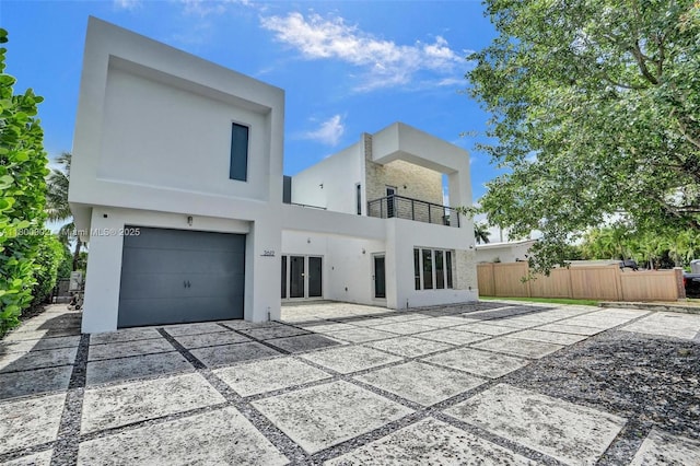2612 Key Largo Ln, Fort Lauderdale, FL 33312 - back of house featuring a balcony, stucco siding, a garage, and driveway