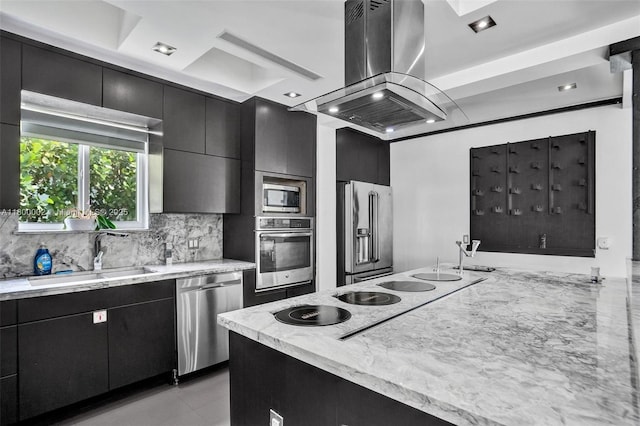 2612 Key Largo Ln, Fort Lauderdale, FL 33312 - kitchen featuring appliances with stainless steel finishes, island exhaust hood, dark cabinetry, and decorative backsplash