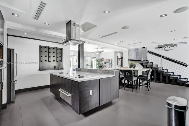 2612 Key Largo Ln, Fort Lauderdale, FL 33312 - kitchen with modern cabinets, appliances with stainless steel finishes, a warming drawer, island exhaust hood, and a kitchen island with sink