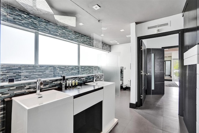 2612 Key Largo Ln, Fort Lauderdale, FL 33312 - kitchen with modern cabinets, white cabinetry, tasteful backsplash, and light tile patterned flooring