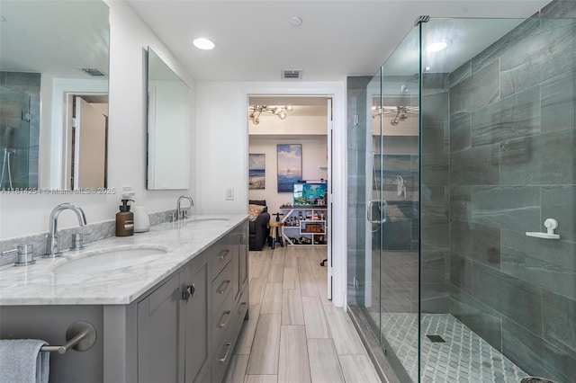 50 Biscayne Blvd Unit 3106, Miami, FL 33132 - bathroom featuring double vanity, a shower stall, a chandelier, ensuite bathroom, and wood tiled floors