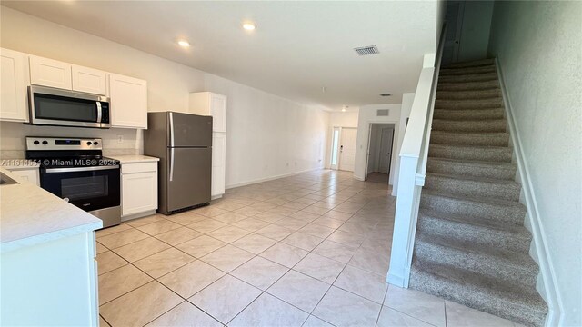 322 NE 1st Dr, Florida City, FL 33034 - kitchen featuring appliances with stainless steel finishes, light countertops, light tile patterned flooring, white cabinetry, and recessed lighting