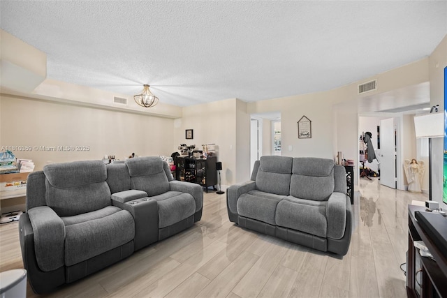 2649 SE 19th Ct Unit 106-D, Homestead, FL 33035 - living area with light wood-style flooring, a textured ceiling, and a chandelier