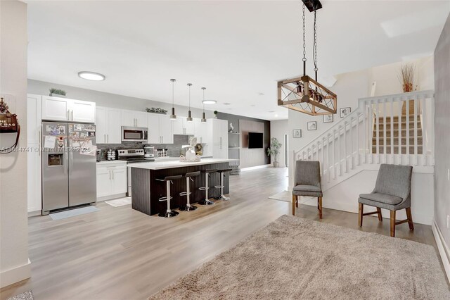 24686 SW 119th Pl, Homestead, FL 33032 - kitchen featuring stainless steel appliances, backsplash, open floor plan, a kitchen island with sink, and white cabinets
