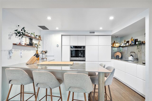 2150 Sans Souci Blvd Unit B311, North Miami, FL 33181 - kitchen with oven, open shelves, modern cabinets, a sink, and recessed lighting
