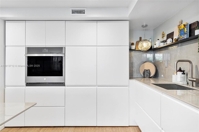 2150 Sans Souci Blvd Unit B311, North Miami, FL 33181 - kitchen featuring oven, modern cabinets, white cabinets, and a sink