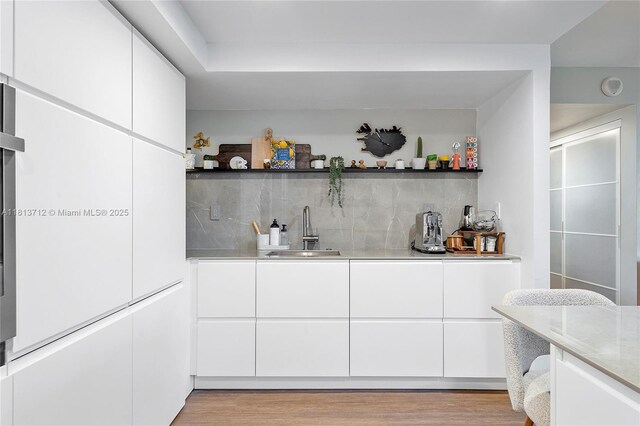 2150 Sans Souci Blvd Unit B311, North Miami, FL 33181 - indoor wet bar featuring decorative backsplash and light wood finished floors