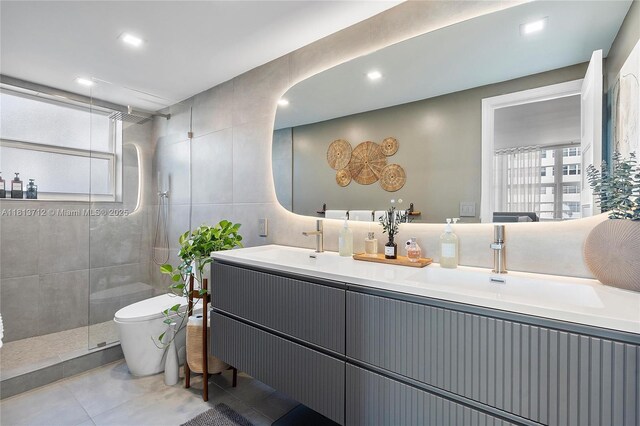 2150 Sans Souci Blvd Unit B311, North Miami, FL 33181 - full bathroom featuring toilet, double vanity, tile walls, tiled shower, and tile patterned flooring