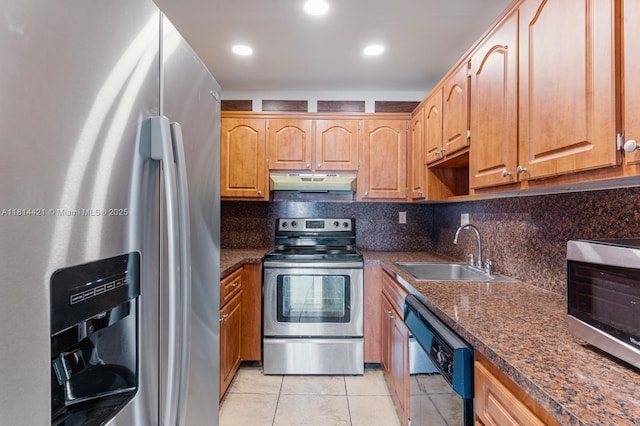 17051 NE 35th Ave Unit 109, North Miami Beach, FL 33160 - kitchen featuring stainless steel appliances, under cabinet range hood, a sink, light tile patterned flooring, and decorative backsplash