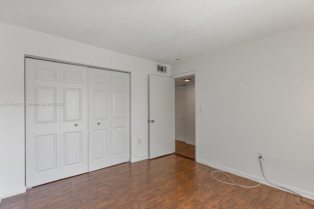 17051 NE 35th Ave Unit 109, North Miami Beach, FL 33160 - unfurnished bedroom featuring wood finished floors, a closet, and a textured ceiling
