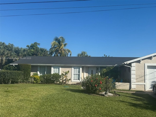 4706 25th Ave SW, Naples, FL 34116 - back of property featuring stucco siding, a lawn, and a garage