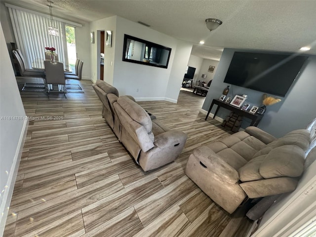 4706 25th Ave SW, Naples, FL 34116 - living room featuring a textured ceiling, wood finish floors, baseboards, and recessed lighting