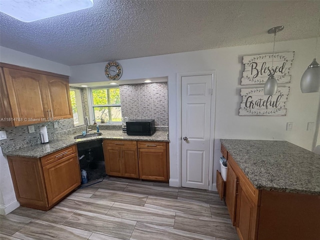 4706 25th Ave SW, Naples, FL 34116 - kitchen featuring a sink, brown cabinets, black microwave, a textured ceiling, and light stone countertops