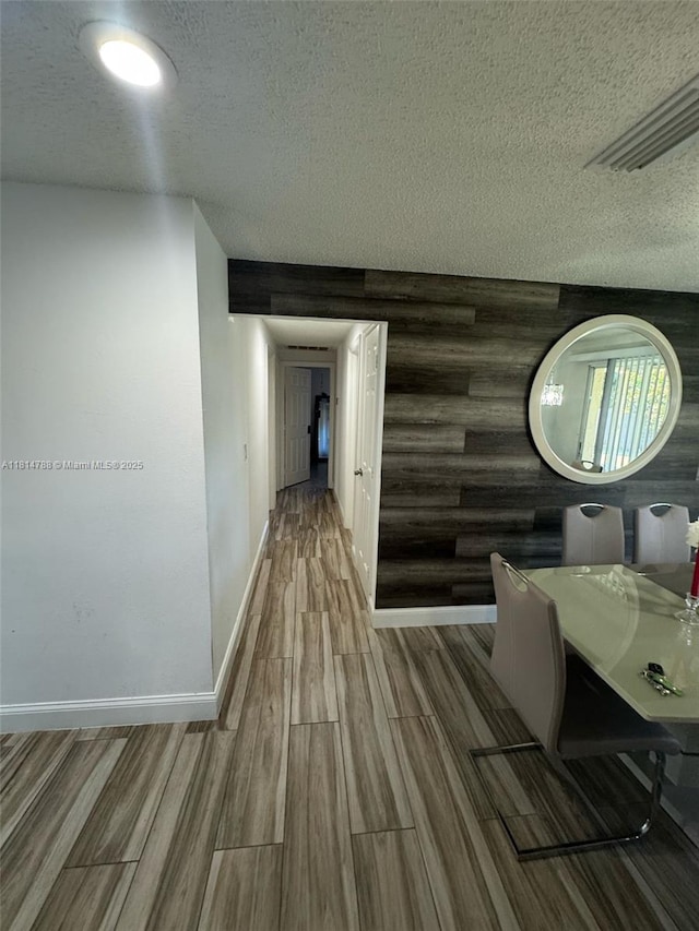 4706 25th Ave SW, Naples, FL 34116 - hall featuring a textured ceiling, wood finished floors, and baseboards