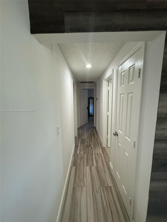 4706 25th Ave SW, Naples, FL 34116 - hallway with a textured ceiling, baseboards, and wood finished floors