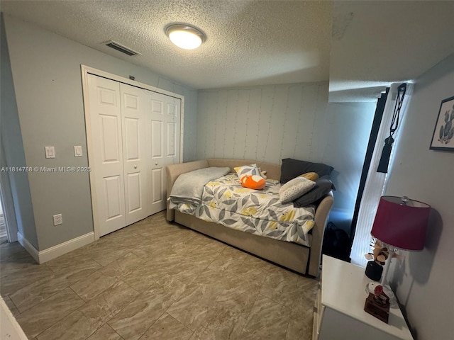4706 25th Ave SW, Naples, FL 34116 - bedroom featuring a textured ceiling, a closet, and baseboards