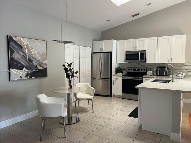18428 Via Di Regina, Boca Raton, FL 33496 - kitchen with stainless steel appliances, a sink, decorative backsplash, high vaulted ceiling, and white cabinetry