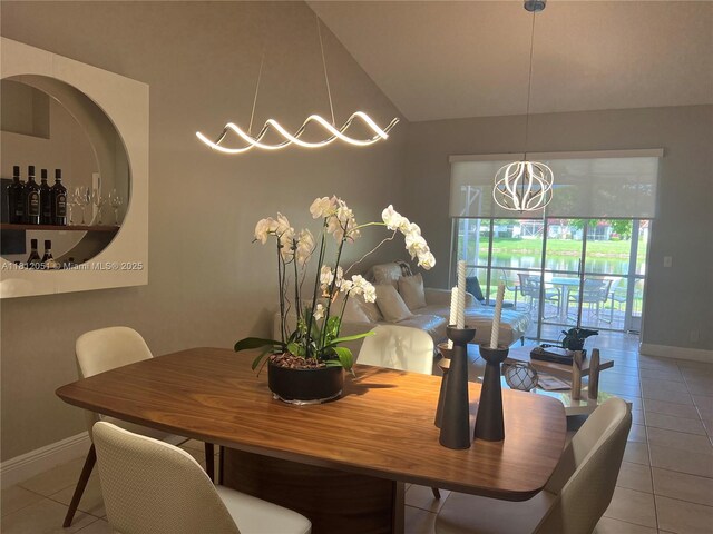 18428 Via Di Regina, Boca Raton, FL 33496 - tiled dining area featuring baseboards, vaulted ceiling, and a chandelier