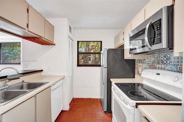 2591 Trapp Ave Unit 4, Miami, FL 33133 - kitchen with white appliances, a sink, brick patterned floors, decorative backsplash, and light countertops