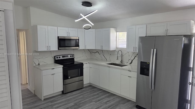 2248 Marina Park Dr, Fort Myers, FL 33905 - kitchen with appliances with stainless steel finishes, white cabinets, tasteful backsplash, wood finished floors, and light stone countertops