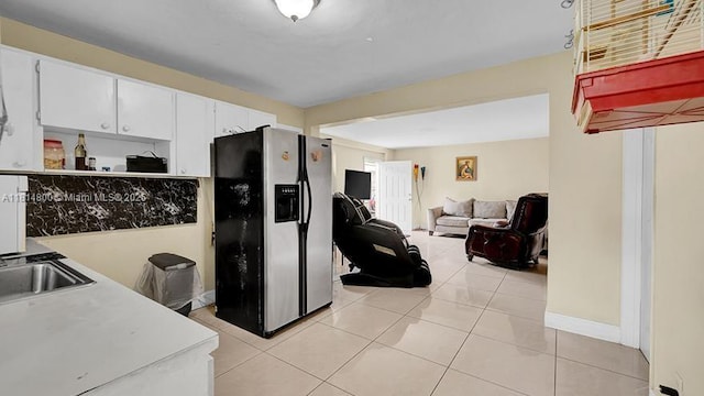 435 NW 44th Ave, Miami, FL 33126 - kitchen featuring stainless steel refrigerator with ice dispenser, white cabinetry, light tile patterned flooring, a sink, and light countertops