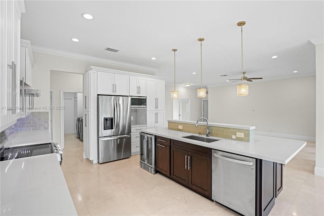 720 Cypress Pointe Dr W, Pembroke Pines, FL 33027 - kitchen featuring stainless steel appliances, a sink, wine cooler, light countertops, and white cabinetry