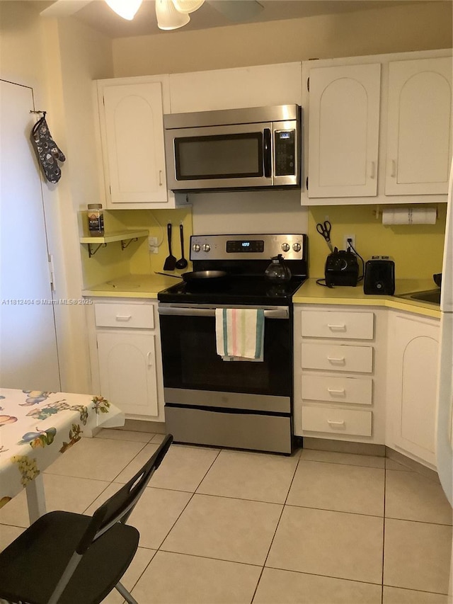 1865 S Ocean Dr Unit 10D, Hallandale Beach, FL 33009 - kitchen featuring appliances with stainless steel finishes, white cabinets, light countertops, and light tile patterned flooring