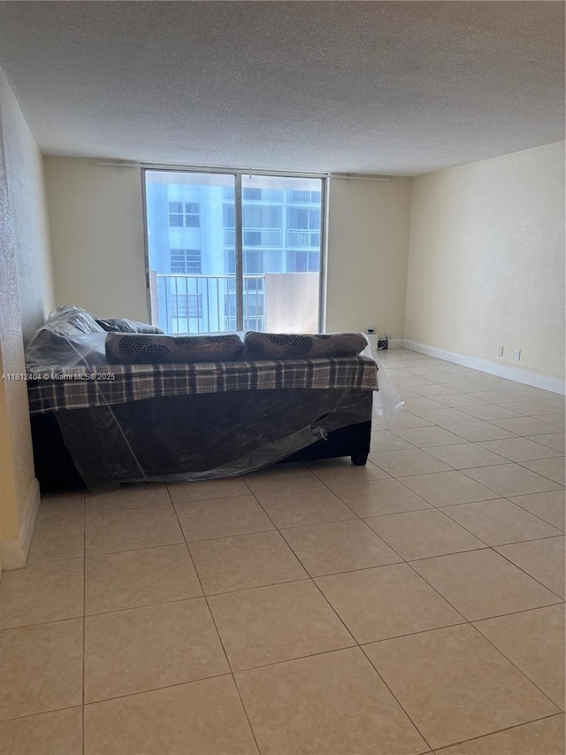 1865 S Ocean Dr Unit 10D, Hallandale Beach, FL 33009 - bedroom featuring light tile patterned floors, a textured ceiling, and baseboards