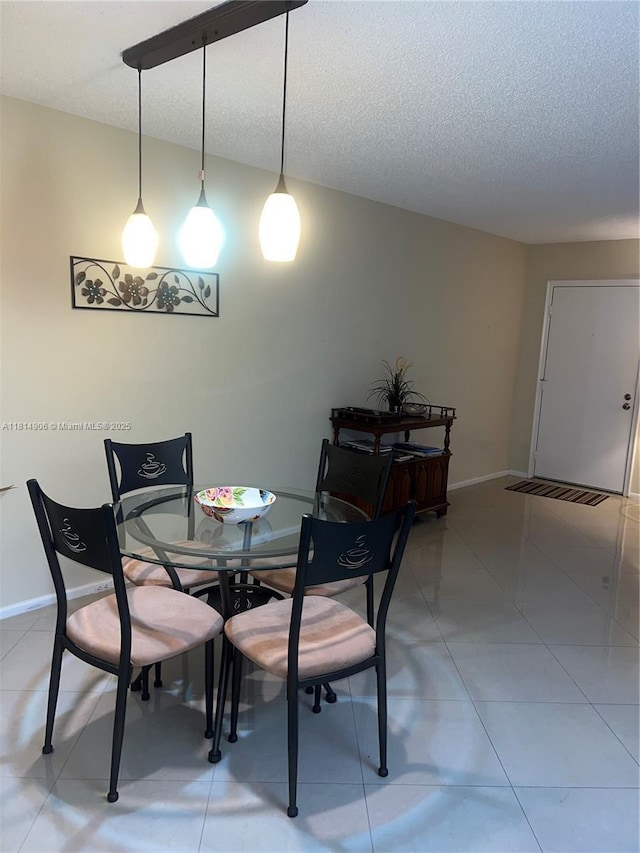 3405 Bimini Ln Unit J4, Coconut Creek, FL 33066 - dining area featuring a textured ceiling, baseboards, and light tile patterned floors