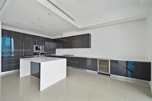 3250 NE 188th St Unit Lph07, Aventura, FL 33180 - kitchen featuring modern cabinets, beverage cooler, a sink, an island with sink, and light countertops